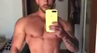 Guy in Black Posing Trunks In Front Of A Mirror